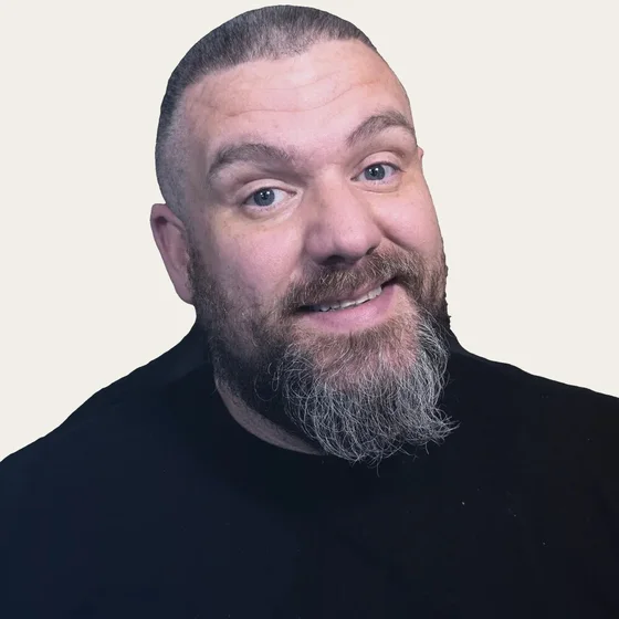 Will Ray, smiling, gray-streaked beard, black t-shirt